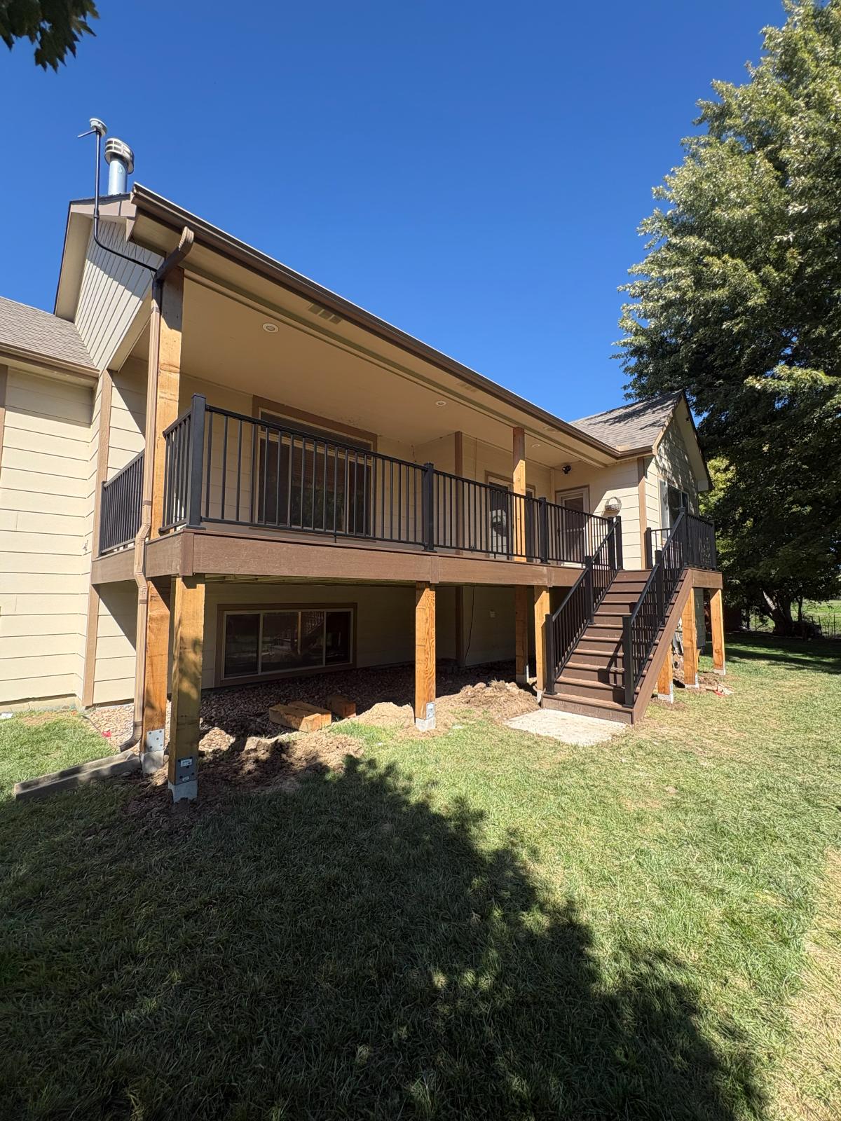 Elevated covered deck with composite decking and black metal railing